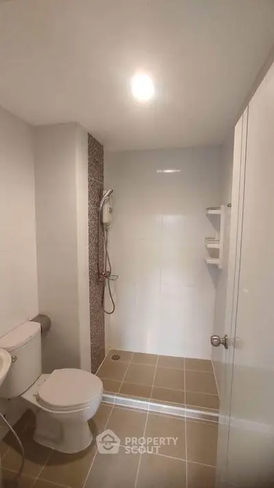 Modern bathroom with shower and toilet in a sleek, minimalist design.