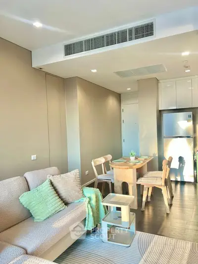 Modern living room with cozy seating and dining area, featuring stylish decor and natural lighting.