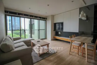 Modern living room with large windows and stylish furniture in a high-rise apartment.