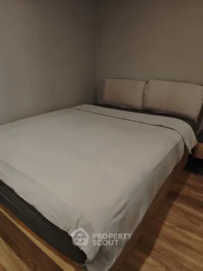 Cozy bedroom with a comfortable bed and wooden flooring, perfect for relaxation.