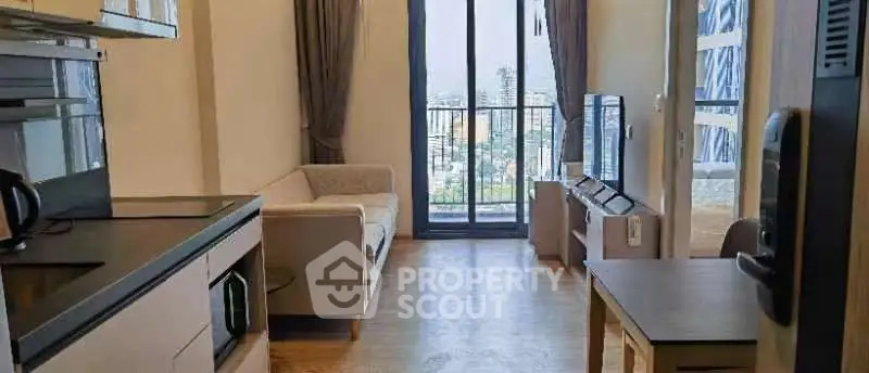 Modern living room with balcony view, featuring sleek furniture and open layout.