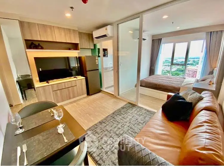 Modern open-plan living room with kitchen and bedroom, featuring stylish decor and large windows with scenic views.