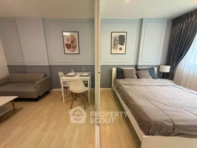 Modern studio apartment with stylish decor, featuring a cozy living area and comfortable bed.