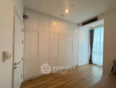 Spacious bedroom with large built-in wardrobe and city view window