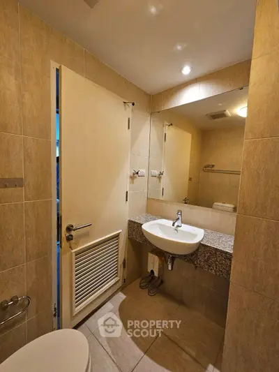 Modern bathroom with sleek design and elegant fixtures, featuring a stylish sink and large mirror.