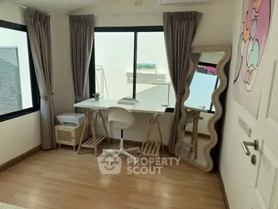 Chic study room with modern desk, stylish mirror, and natural light for a perfect work-from-home setup.