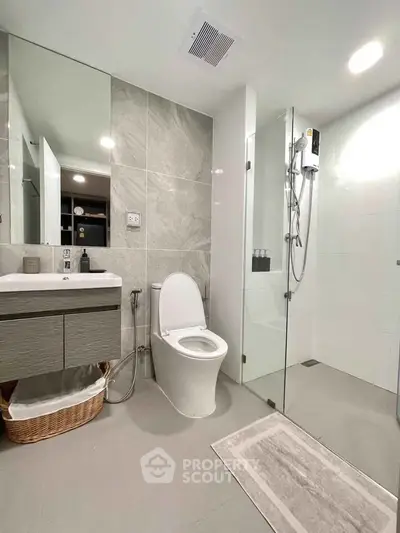 Modern bathroom with sleek design, featuring a glass shower, elegant vanity, and contemporary fixtures.