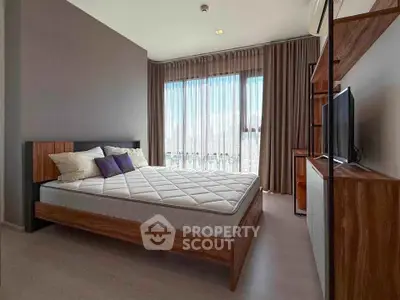 Modern bedroom with large window and stylish wooden furniture in a high-rise apartment.