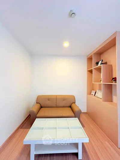 Cozy living room with modern sofa and stylish built-in shelving, perfect for relaxation and decor display.