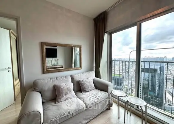 Modern living room with city view and cozy sofa in high-rise apartment.