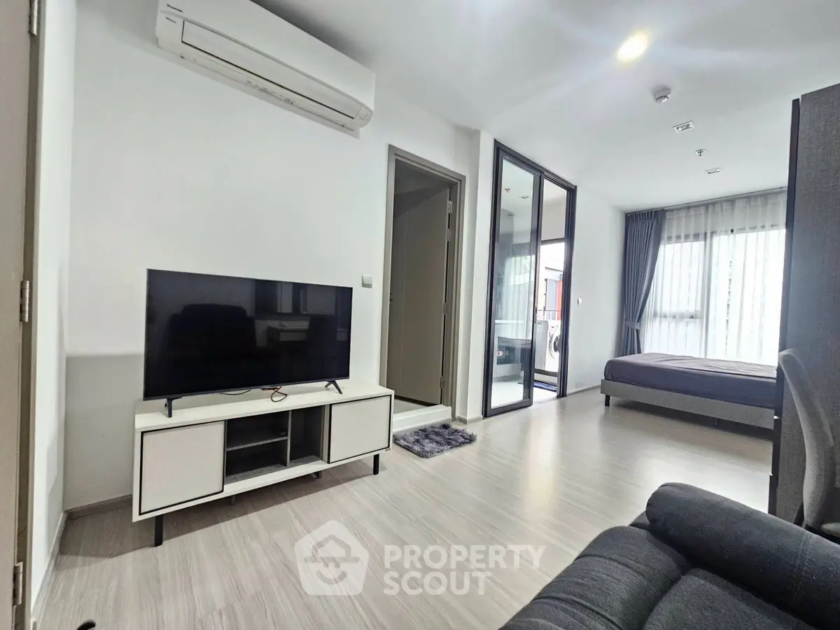 Modern open-plan living room with TV and air conditioning in a stylish apartment