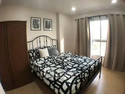 Cozy bedroom with stylish decor and natural light from large window