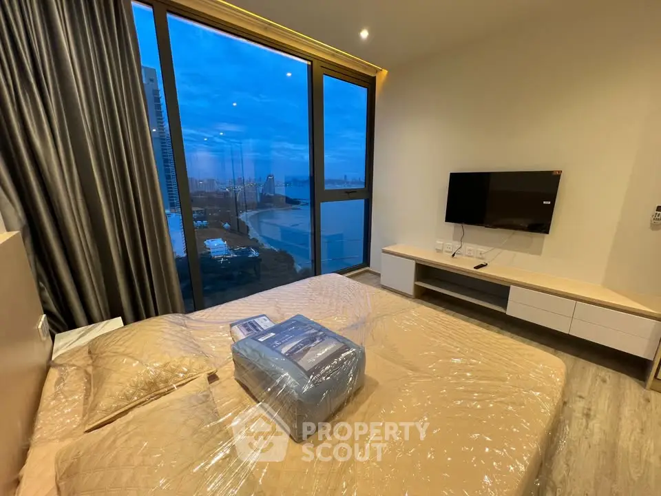 Modern bedroom with large window offering stunning city view