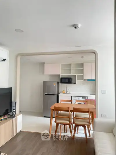 Modern open-layout kitchen and dining area with sleek appliances and stylish furniture.