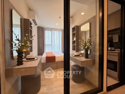 Modern bedroom with stylish decor and natural light, featuring mirrored walls and elegant furnishings.