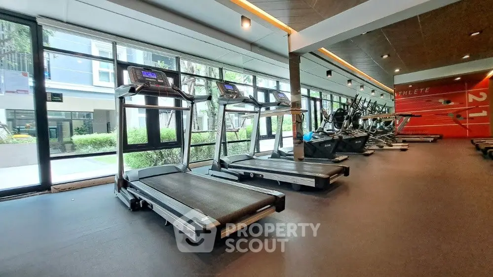 Modern gym with treadmills and exercise equipment in a luxury apartment complex.