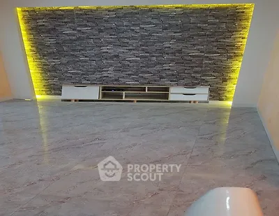 Modern living room with stylish stone accent wall and ambient lighting