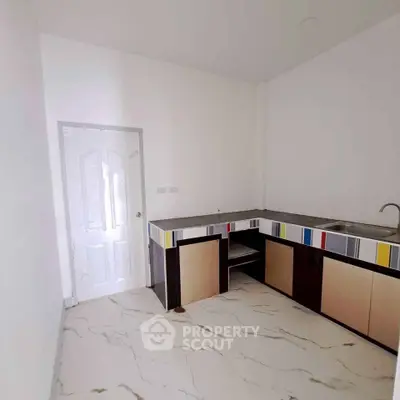 Modern kitchen with sleek cabinetry and marble flooring in a minimalist design.
