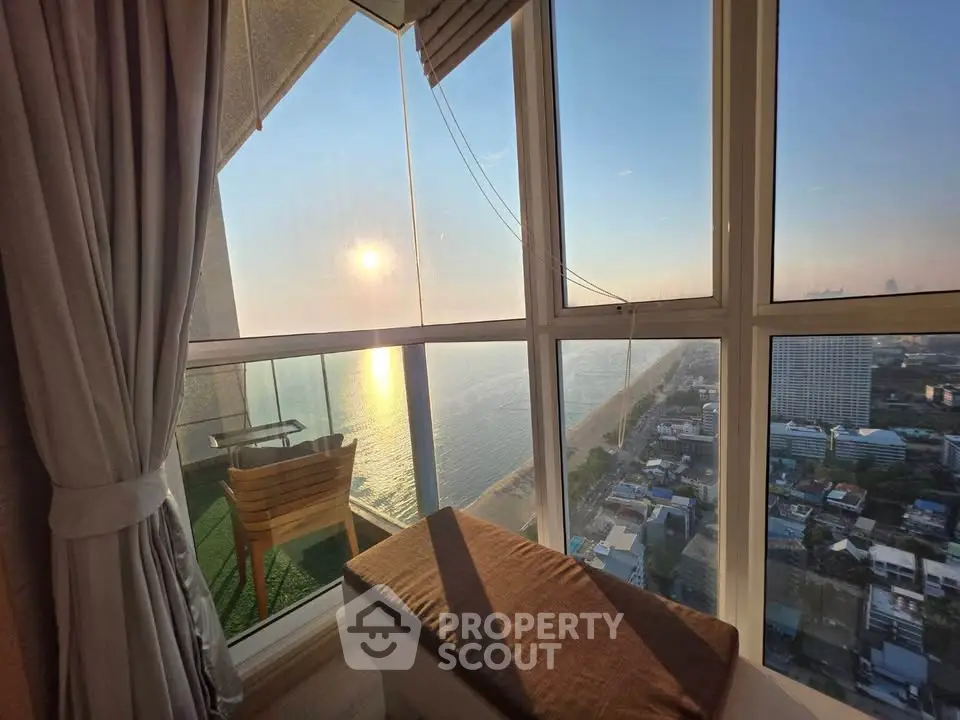 Stunning high-rise balcony view overlooking the ocean at sunset, perfect for relaxation and enjoying the scenery.