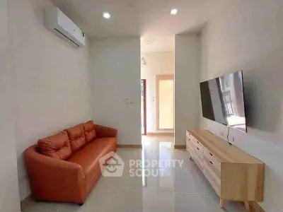 Modern living room with sleek TV setup and cozy leather sofa