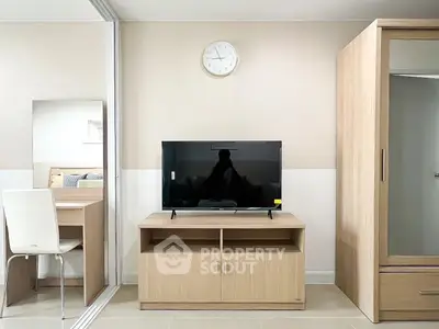 Modern living room with sleek TV stand and mirrored wardrobe in stylish apartment.