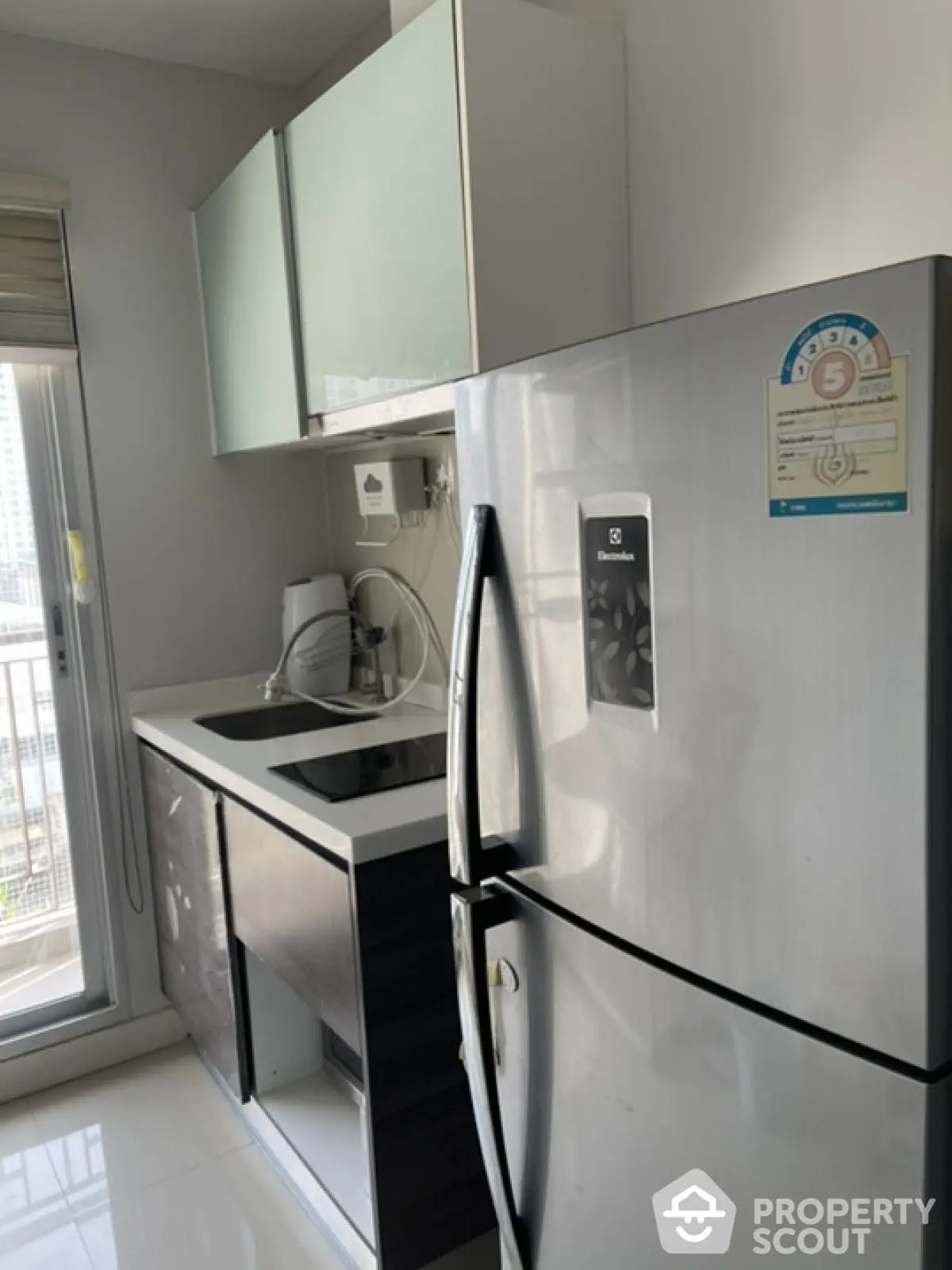 Modern kitchen with stainless steel fridge and sleek cabinetry in a bright apartment