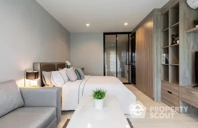 Elegant bedroom with modern furnishings, neutral tones, and a cozy sitting area, seamlessly connecting to a sleek en-suite bathroom.