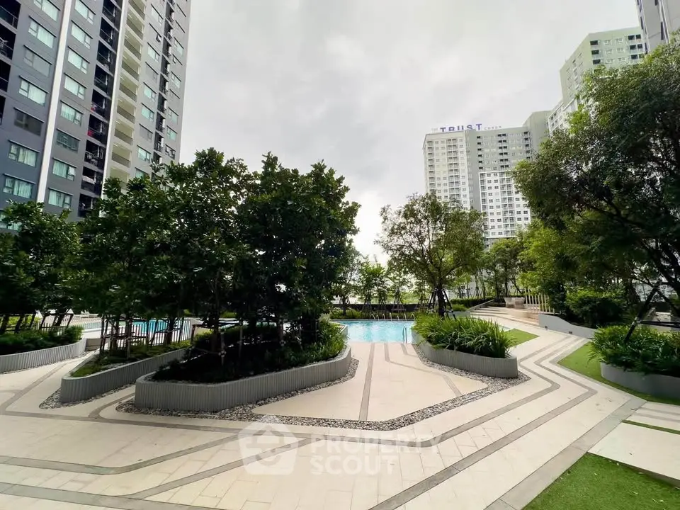 Modern residential complex with lush gardens and inviting pool area.