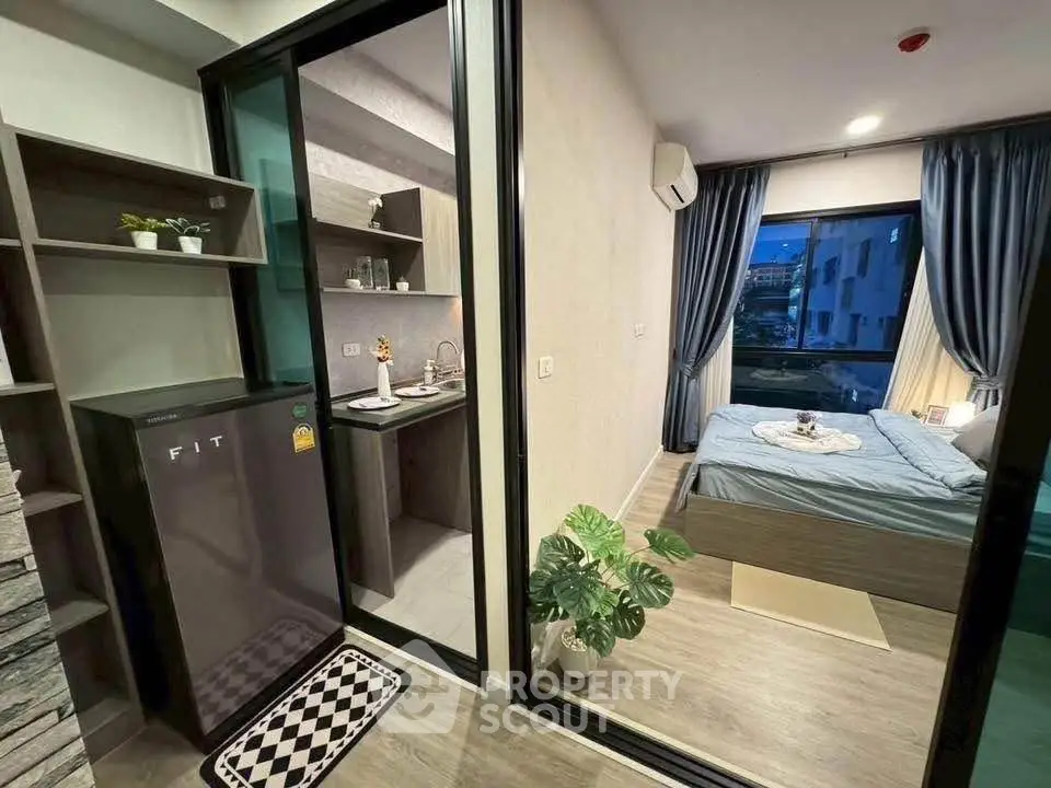 Modern studio apartment with compact kitchen and cozy bedroom, ideal for urban living.