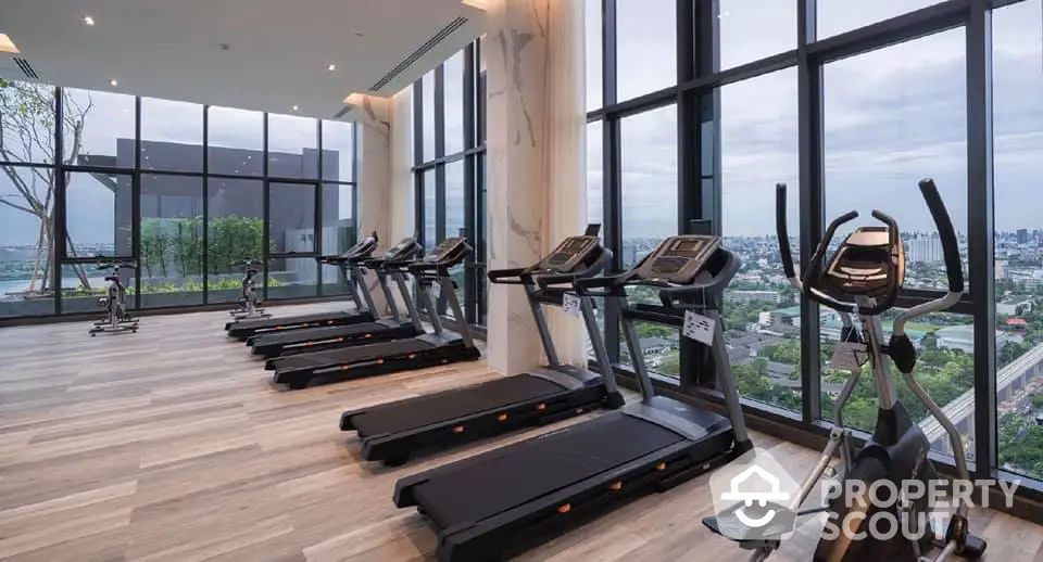 Luxurious high-rise gym with panoramic city views and modern fitness equipment.