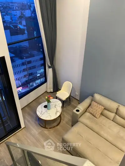 Modern living room with high ceiling and city view, featuring a cozy sofa and elegant decor.
