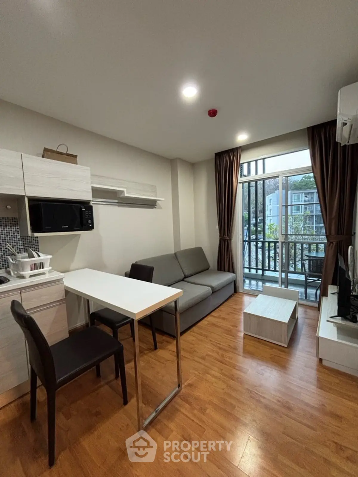 Modern living room with sleek furniture and balcony view in a stylish apartment.