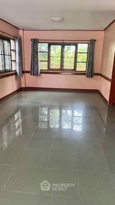 Spacious empty living room with large windows and tiled floor