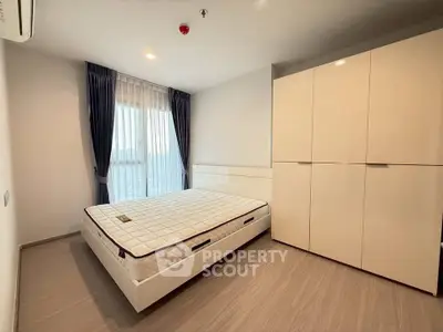 Modern bedroom with sleek wardrobe and large window for natural light