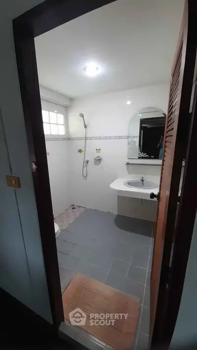 Compact bathroom with shower and sink in modern apartment