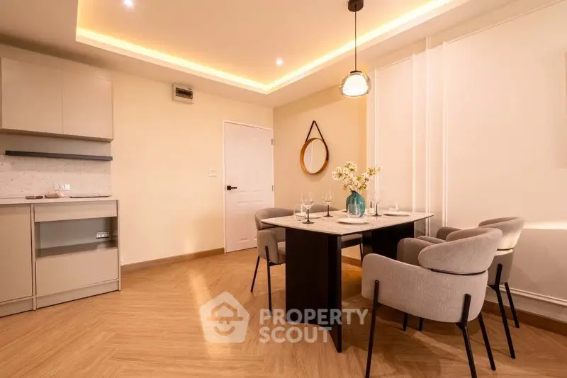 Modern dining area with elegant lighting and stylish furniture in a contemporary apartment.