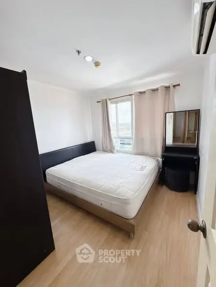 Cozy bedroom with natural light and modern furnishings, perfect for relaxation.