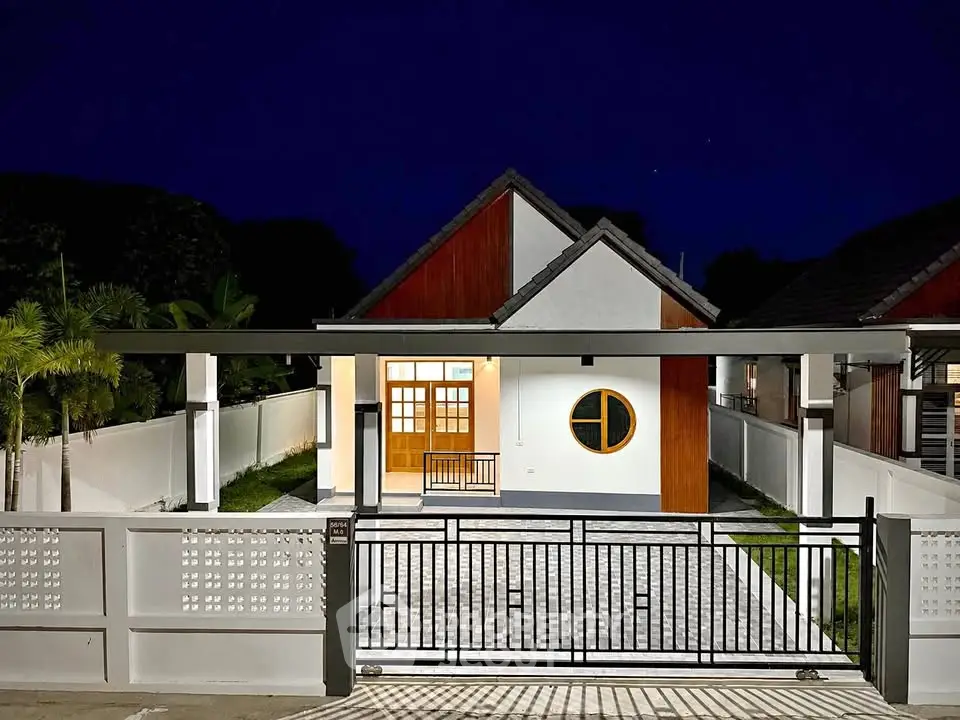 Charming modern house with unique circular window and spacious driveway, perfect for serene living.