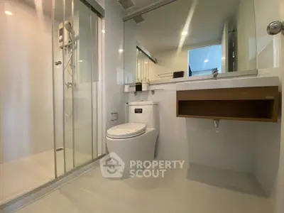 Modern bathroom with sleek shower and contemporary fixtures in a stylish apartment.
