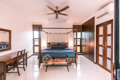 Spacious bedroom with elegant wooden furniture and ceiling fan, perfect for relaxation.