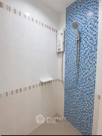 Modern bathroom shower with blue mosaic tiles and sleek fixtures