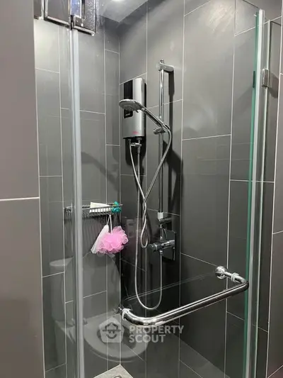 Modern bathroom with sleek shower design and dark tile walls