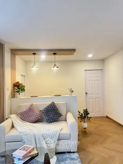 Modern living room with cozy sofa and stylish lighting, perfect for relaxation.