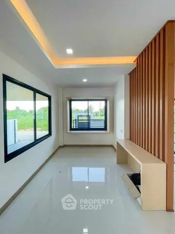 Modern living room with large windows and sleek design in a bright, open space.