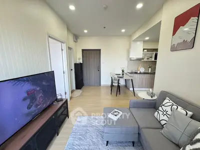 Modern living room with open kitchen, stylish decor, and cozy seating area in a contemporary apartment.