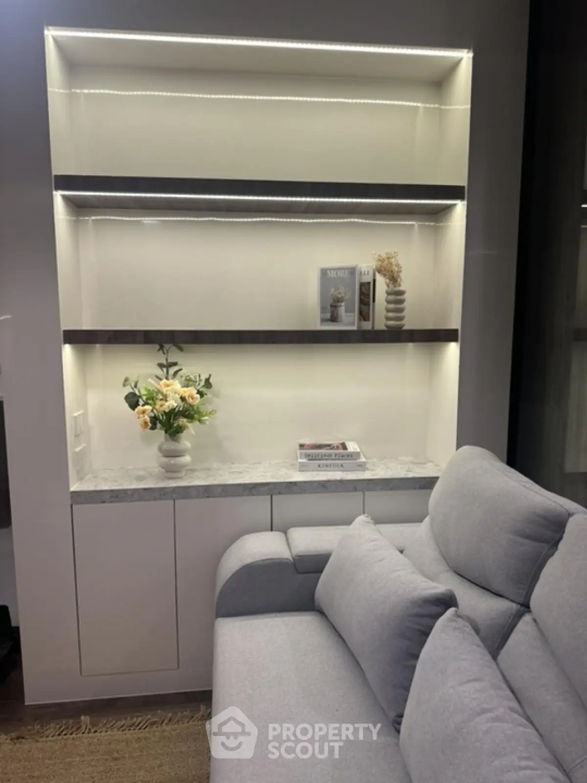 Modern living room with stylish shelving and cozy gray sofa