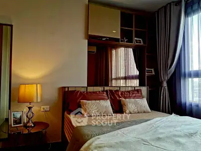 Cozy bedroom with elegant decor and natural light from large window.