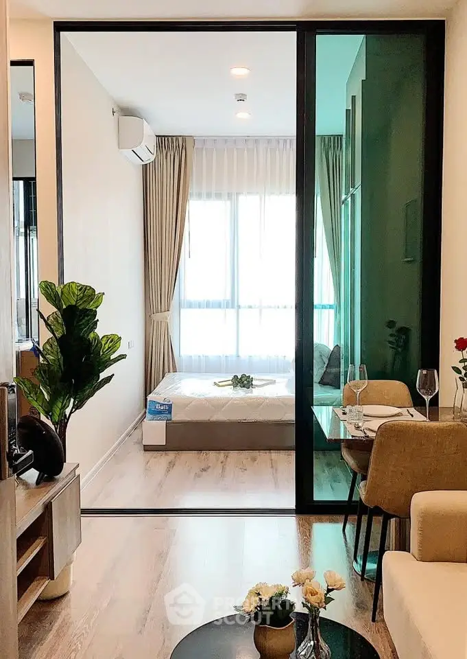 Modern living room with glass partition and cozy bedroom view