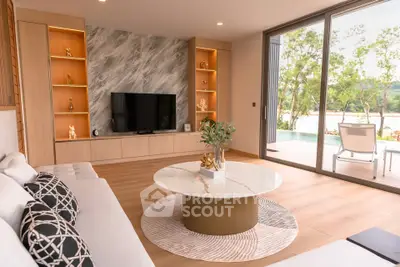 Luxurious living room with modern decor and large glass doors opening to a scenic balcony view.