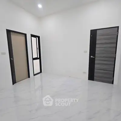 Spacious room with modern doors and glossy white tile flooring, perfect for customization.